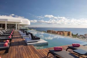 a row of lounge chairs on a hotel swimming pool at Royal Hideaway Corales Beach - Adults Only in Adeje