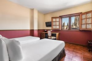 una camera d'albergo con due letti e una finestra di Crisol Mesón del Cid a Burgos