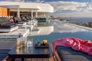 a pool with couches and a table next to the ocean at Royal Hideaway Corales Beach - Adults Only in Adeje