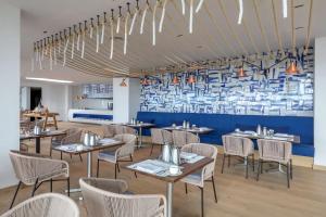 a restaurant with tables and chairs and a blue wall at Royal Hideaway Corales Beach - Adults Only in Adeje