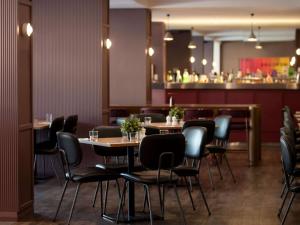 柏斯的住宿－Mercure Perth On Hay，一间带桌椅的餐厅和一间酒吧