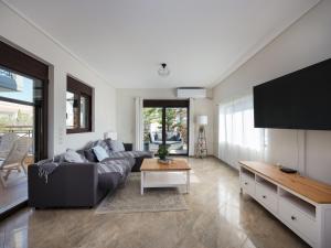 a living room with a couch and a table at Galina's Greek House in Artemida