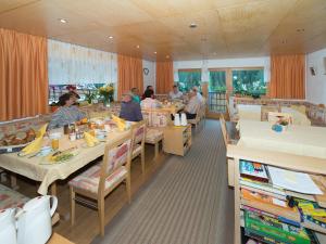 un comedor con gente sentada en las mesas de un restaurante en Haus Margrith Alpenblick Appartements, en Damüls