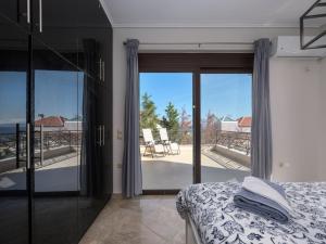 a bedroom with a bed and a view of a balcony at Galina's Greek House in Artemida