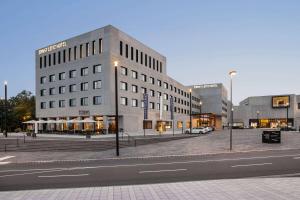 a building on a city street with a street at Ernst Leitz Hotel Wetzlar direkt neben der Leica Welt in Wetzlar
