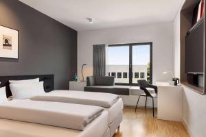 a hotel room with two beds and a window at Ernst Leitz Hotel Wetzlar direkt neben der Leica Welt in Wetzlar