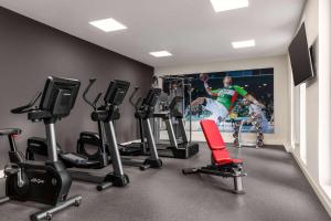 a gym with cardio equipment and a poster of a soccer player at Vienna House by Wyndham Ernst Leitz Wetzlar in Wetzlar