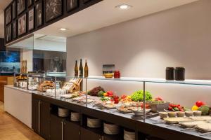 a buffet line with food and bottles of wine at Vienna House by Wyndham Ernst Leitz Wetzlar in Wetzlar