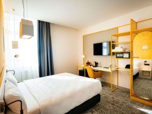a hotel room with a bed and a desk at Ibis Styles Sibiu Arsenal in Sibiu