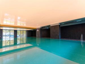 a swimming pool in a building with a swimming pool at Ibis Styles Sibiu Arsenal in Sibiu