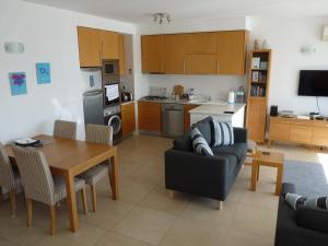 a kitchen and living room with a couch and a table at Rainha Juliana in Fuzeta +15 photos