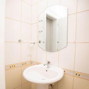 een witte badkamer met een wastafel en een spiegel bij Suprem Apartment Modern Studio Near City Center, Self Check-in & Fast Wi-Fi in Tirana