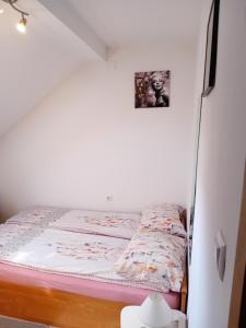un piccolo letto in una stanza con parete bianca di SOBE ŠOKČIĆ a Karlovac
