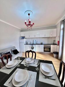 een eettafel met stoelen en een kroonluchter in een keuken bij Blue Paradise Apartment in Ribeira Brava