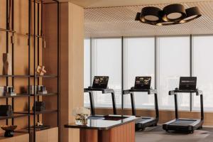 una habitación con tres escritorios de cintas de correr con ordenadores portátiles. en One&Only One Za'abeel en Dubái
