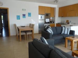 a living room with a couch and a table and a kitchen at Rainha Juliana in Fuzeta