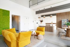 a living room with yellow furniture and a kitchen at Ona Living Barcelona in Hospitalet de Llobregat