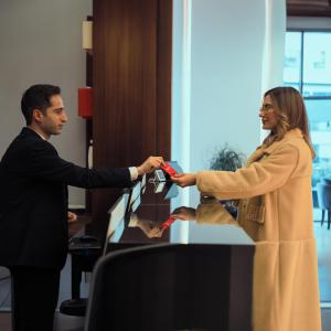 a man and a woman holding a remote control at Ramada Hotel & Suites by Wyndham Erbil 32 Park in Erbil