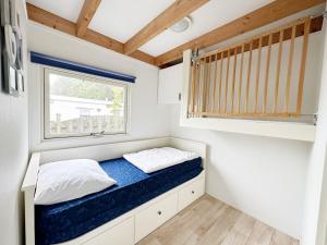 a small bedroom with a bed in a tiny house at Chalet 560 op Recreatiepark De Wielen in Sint Maarten +21 photos