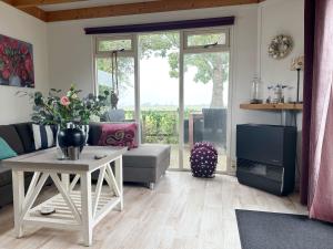 a living room with a couch and a table at Chalet 560 op Recreatiepark De Wielen in Sint Maarten