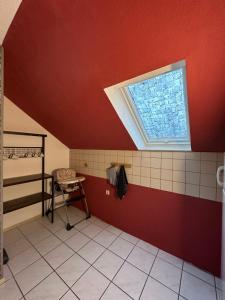 baño con pared roja y ventana en Ferienwohnung Forest en Nonnweiler