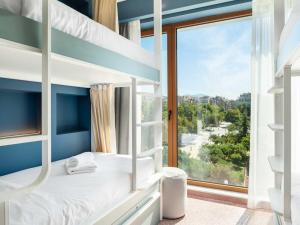 a bedroom with bunk beds with a large window at Zeus is Loose in Thessaloniki