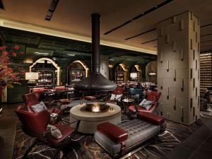 a lobby with a bar with chairs and a fireplace at Hotel Sosei Sapporo MGallery Collection in Sapporo