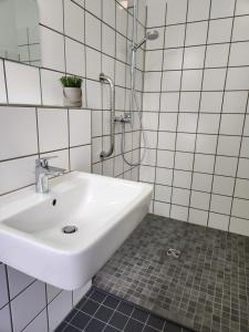 uma casa de banho branca com um lavatório e um chuveiro em Balcony II Appartement em Bad Salzuflen