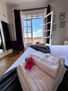 a bedroom with a bed with a flower on it at Blue Paradise Apartment in Ribeira Brava