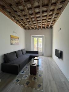 un salon avec un canapé et une télévision dans l'établissement El Chicuco en el corazón de Cádiz Grupo AC Gestion, à Cadix