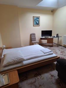 a bedroom with a bed and a desk with a computer at Hotel Malwa in Ostrów Wielkopolski