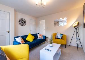 a living room with a blue couch and yellow chairs at Derby Mandarin 3 Bedroom Apartment with Garden and Parking in Derby