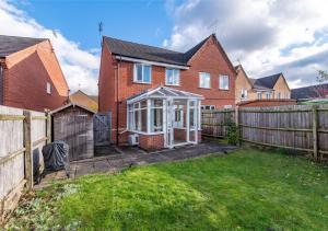 a house with a garden and a fence at Derby Mandarin 3 Bedroom Apartment with Garden and Parking in Derby