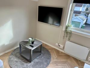 a living room with a table and a flat screen tv at Modern Central Apartment Apt 203 Studio in Stavanger