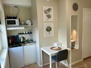 a small kitchen with a small white table and a counter at Modern Central Apartment Apt 203 Studio in Stavanger