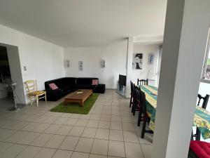 ein Wohnzimmer mit Sofa und Tisch in der Unterkunft Appartement 3 Chambres Centre ville in Lacanau