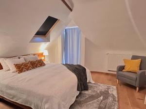 um quarto com uma cama grande e uma cadeira em Villa Mosan Bord de Meuse - Mes Caprices B&B em Namur