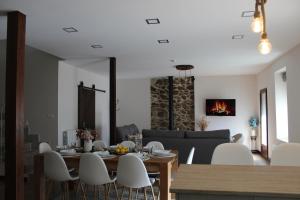 a dining room and living room with a table and chairs at Casa Paula in Segurilla