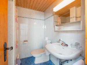 ein weißes Bad mit einem Waschbecken und einem WC in der Unterkunft Haus Armina in Zermatt