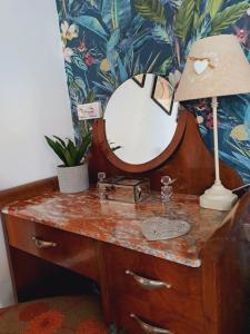 a dressing table with a mirror and a lamp on it at Gite Florence near Saint Chinian Private Pool & River Garden in Pierrerue