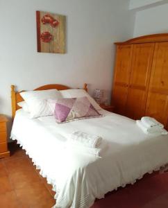 a bedroom with a white bed with a wooden headboard at El Cano Playa Victoria Grupo AC Gestion in Cádiz