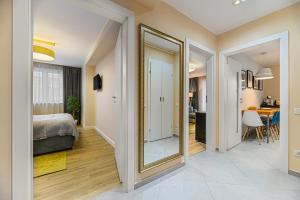 ein Schlafzimmer mit einem Spiegel, einem Bett und einem Tisch in der Unterkunft ARA Apart Hotel #4 in Braşov