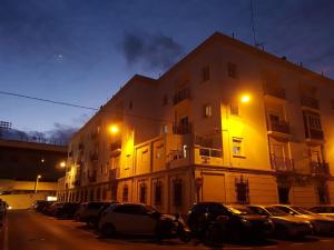 a building with cars parked in a parking lot at night at El Cano Playa Victoria Grupo AC Gestion in Cádiz