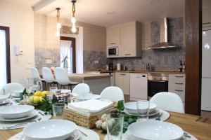 cocina con mesa de comedor con sillas blancas en Casa Paula, en Segurilla