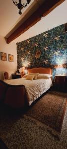 a bedroom with a large bed with a floral wall at Gite Florence near Saint Chinian Private Pool & River Garden in Pierrerue