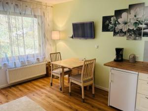 a kitchen with a table and chairs and a television at Ferienwohnung Sonneck in Altenahr