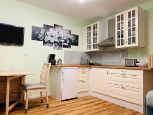 a kitchen with white cabinets and a table and a chair at Ferienwohnung Sonneck in Altenahr