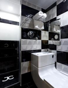 Baño en blanco y negro con lavabo y espejo en JC Rooms Madrid Rio, en Madrid