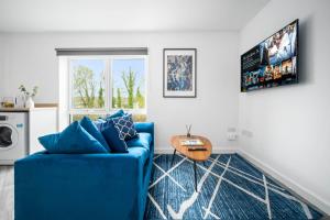 a living room with a blue couch and a table at Modern 2 Bedroom Apartment - Secure Parking - 53C in Sleightholme