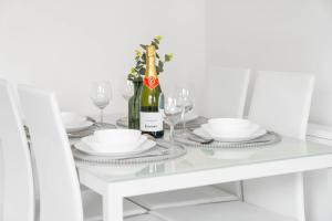 a white table with a bottle of wine and glasses at Modern 2 Bedroom Apartment - Secure Parking - 53C in Sleightholme